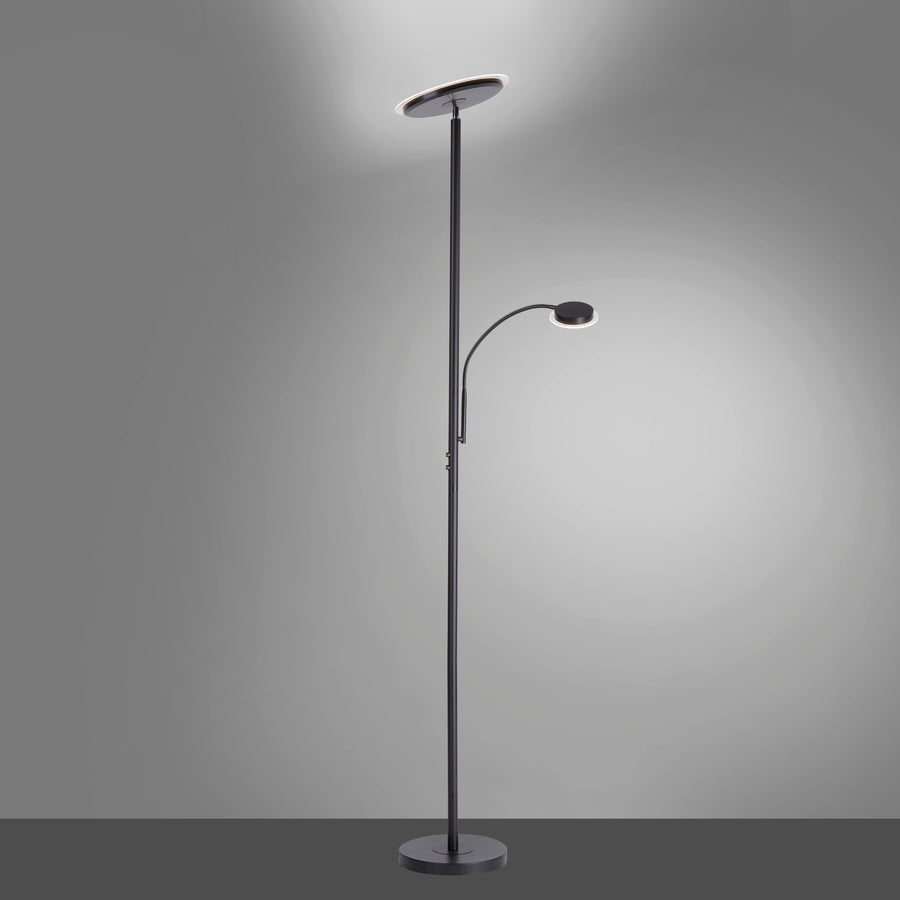 Lampadaire allumé dans une pièce sombre, halo lumineux diffusé au plafond