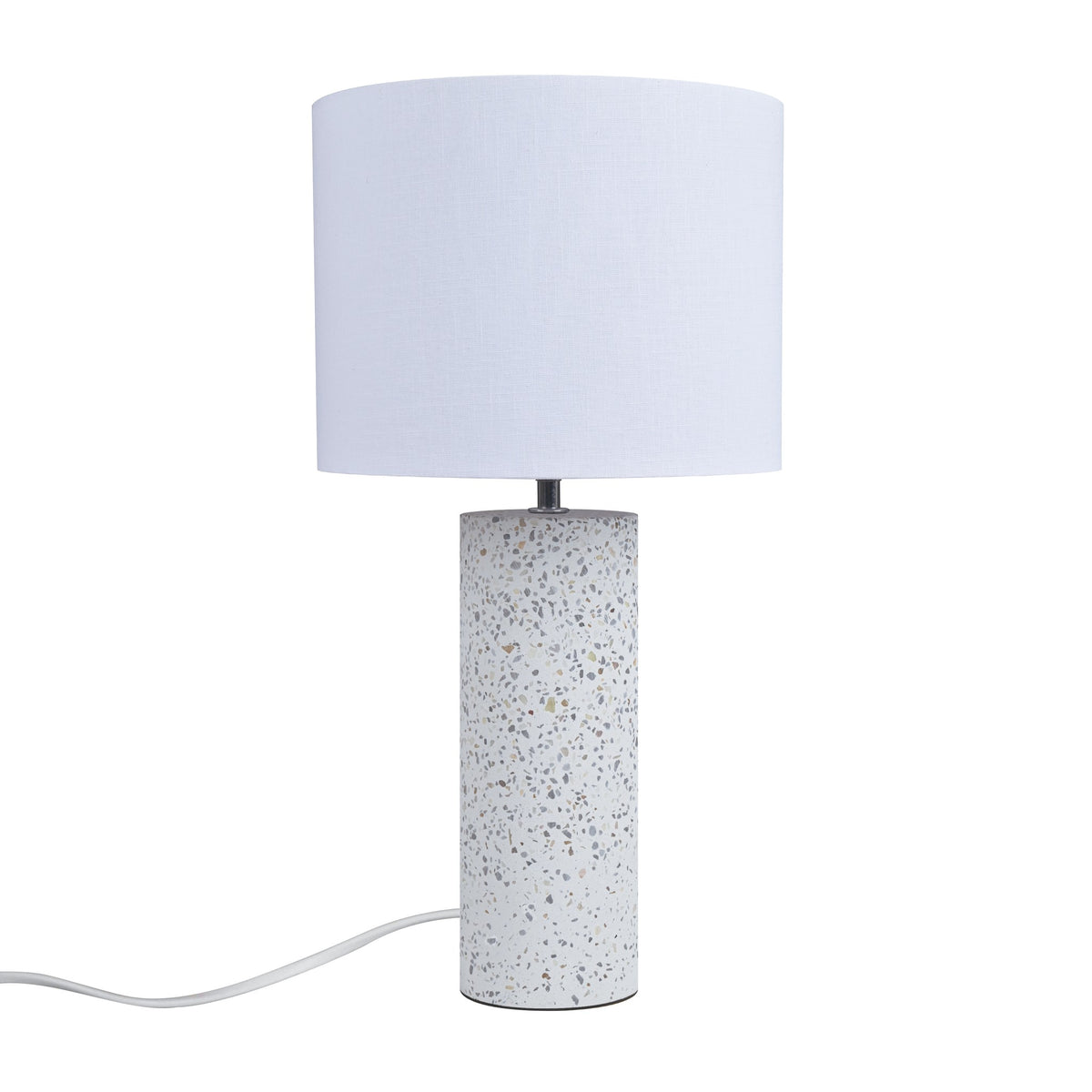 Lampe à poser blanche éteinte, abat-jour tissu cylindrique et base terrazzo mouchetée
