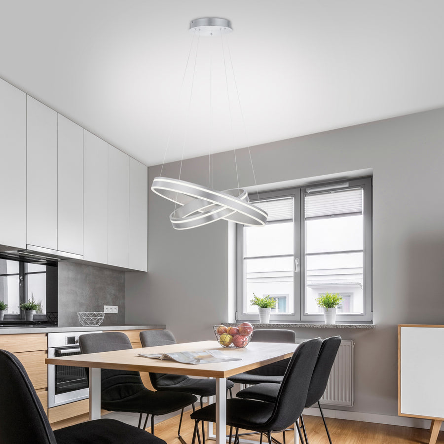 Suspension installée au-dessus d'une table de salle à manger dans une cuisine moderne.