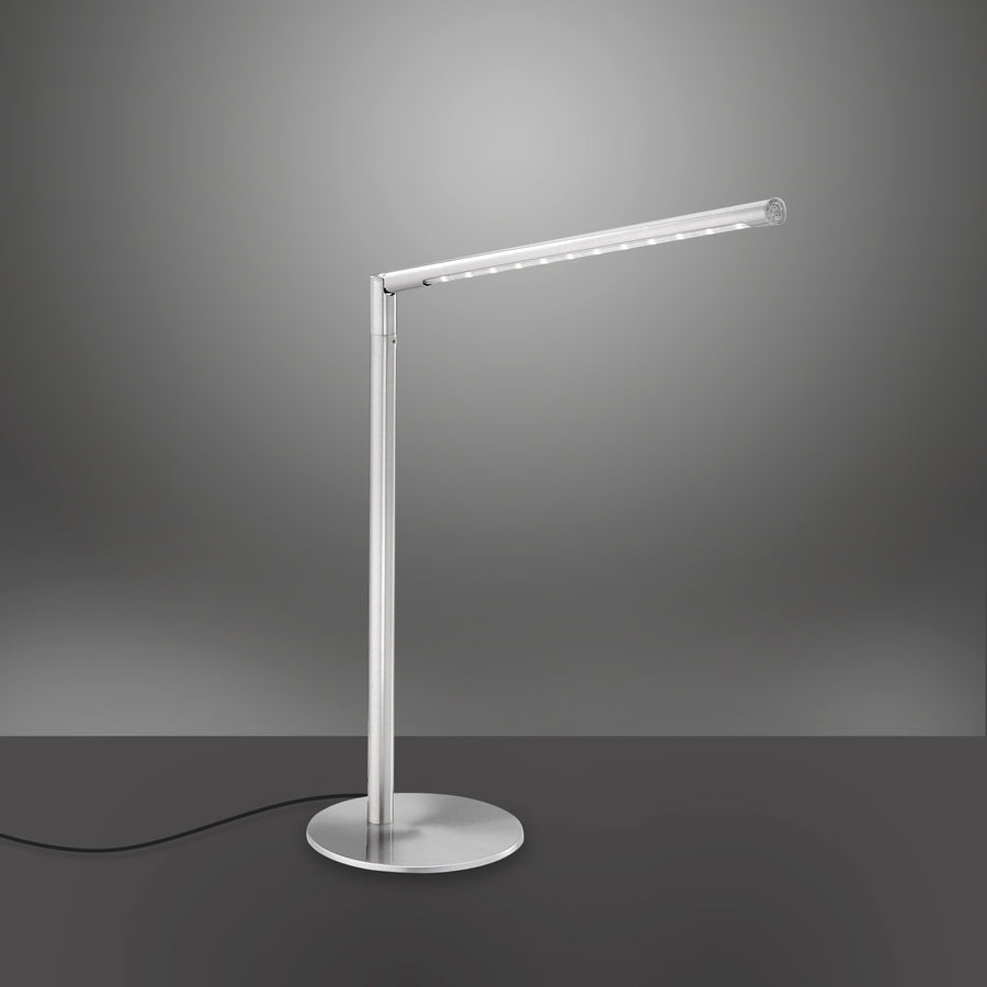 Luminaire argenté de trois quarts avec câble noir apparent sur fond dégradé sombre.