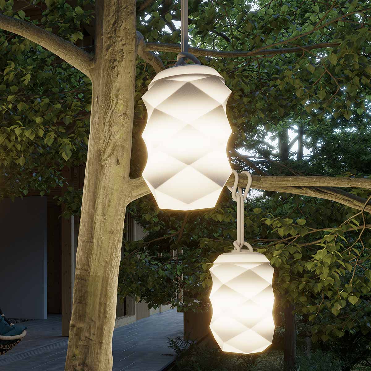 Deux suspensions lumineuses blanches suspendues aux branches, éclairant un jardin arboré au crépuscule.