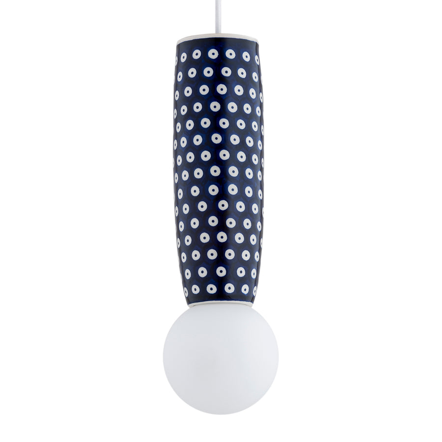 Plan serré sur l'abat-jour cylindrique bleu à pois blancs et sa boule