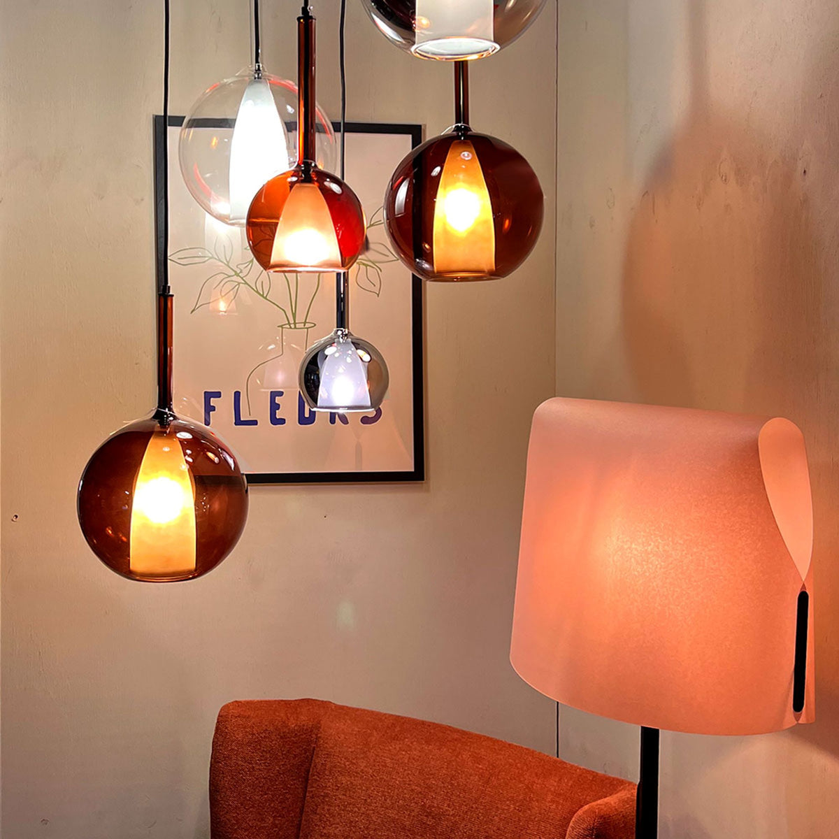 Suspensions ambrées, transparentes et fumées devant une affiche encadrée, lampe à poser