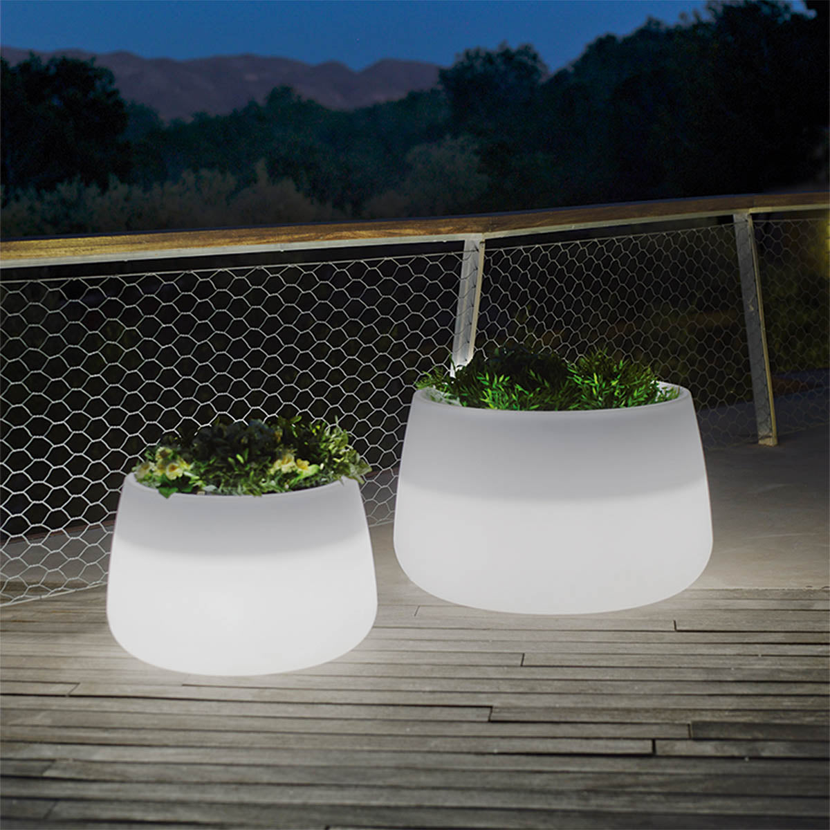 Deux jardinières lumineuses de tailles différentes sur une terrasse au crépuscule