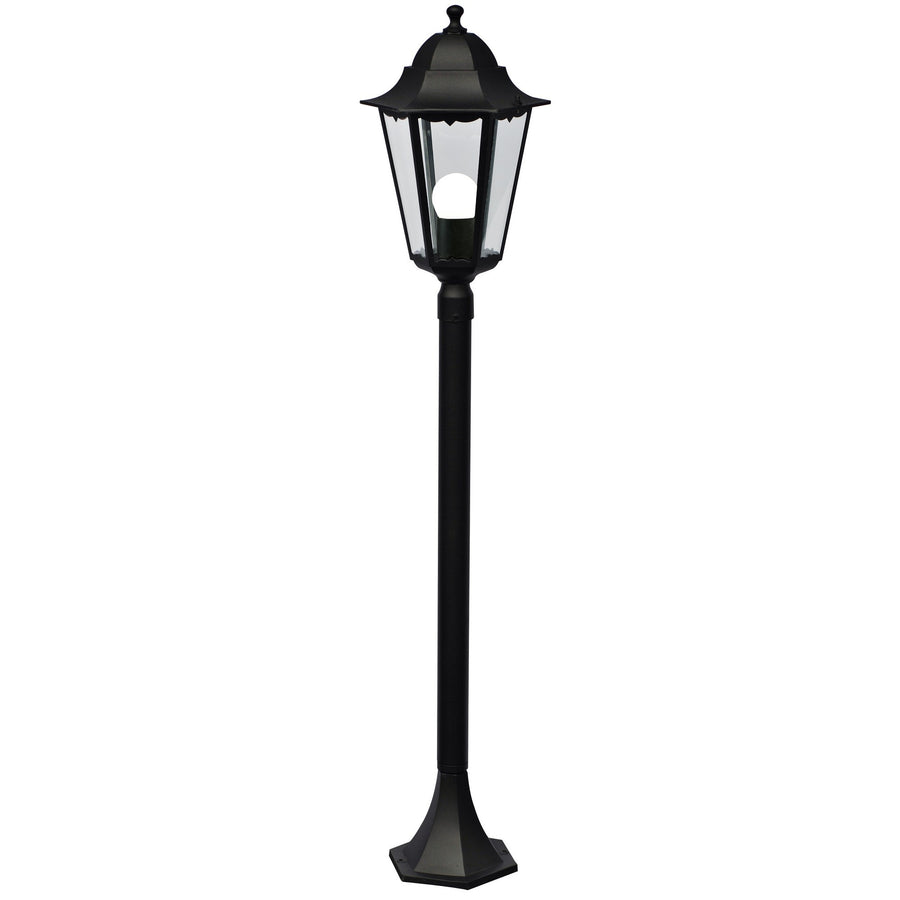 Borne luminaire noire de face sur fond blanc, lanterne hexagonale vitrée et fût vertical