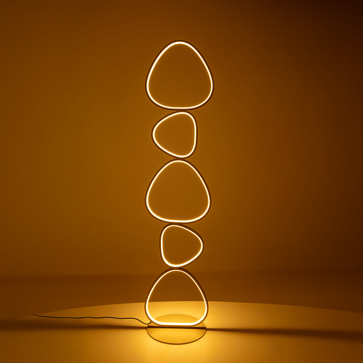 Lampadaire allumé dans une ambiance orangée, diffusant une lumière chaude et enveloppante.