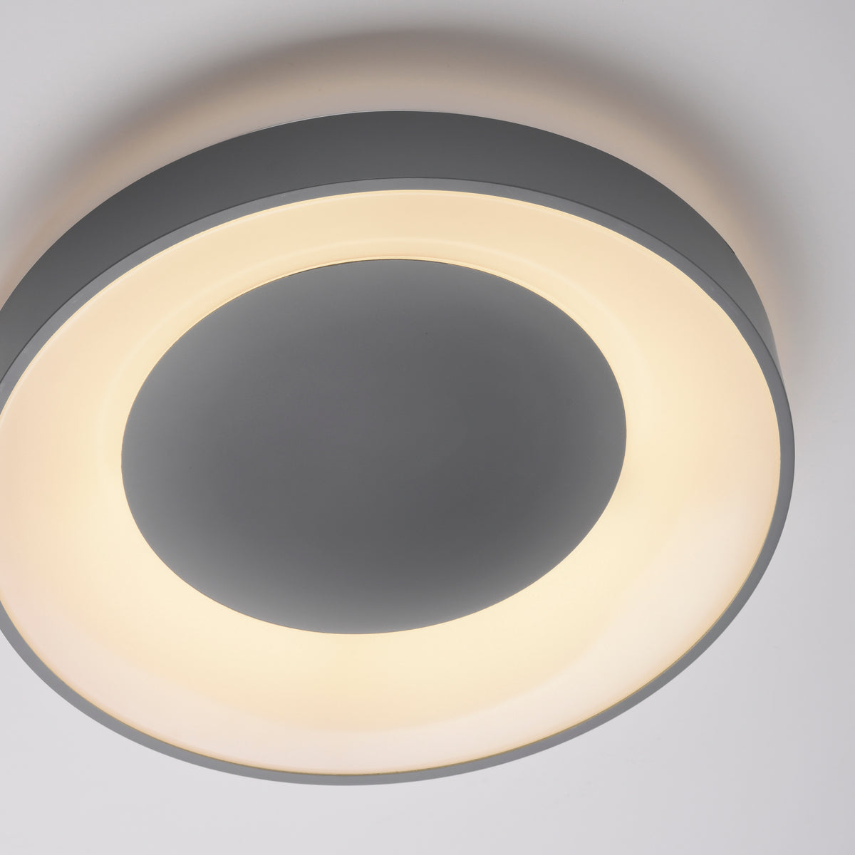 Vue de face rapprochée du luminaire allumé avec large anneau lumineux
