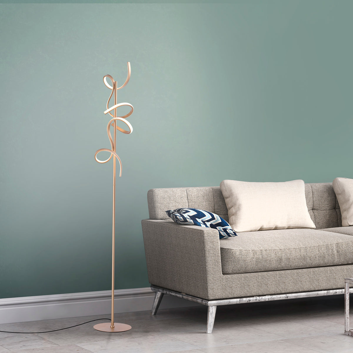 Lampadaire doré installé près d'un canapé beige devant un mur vert sauge