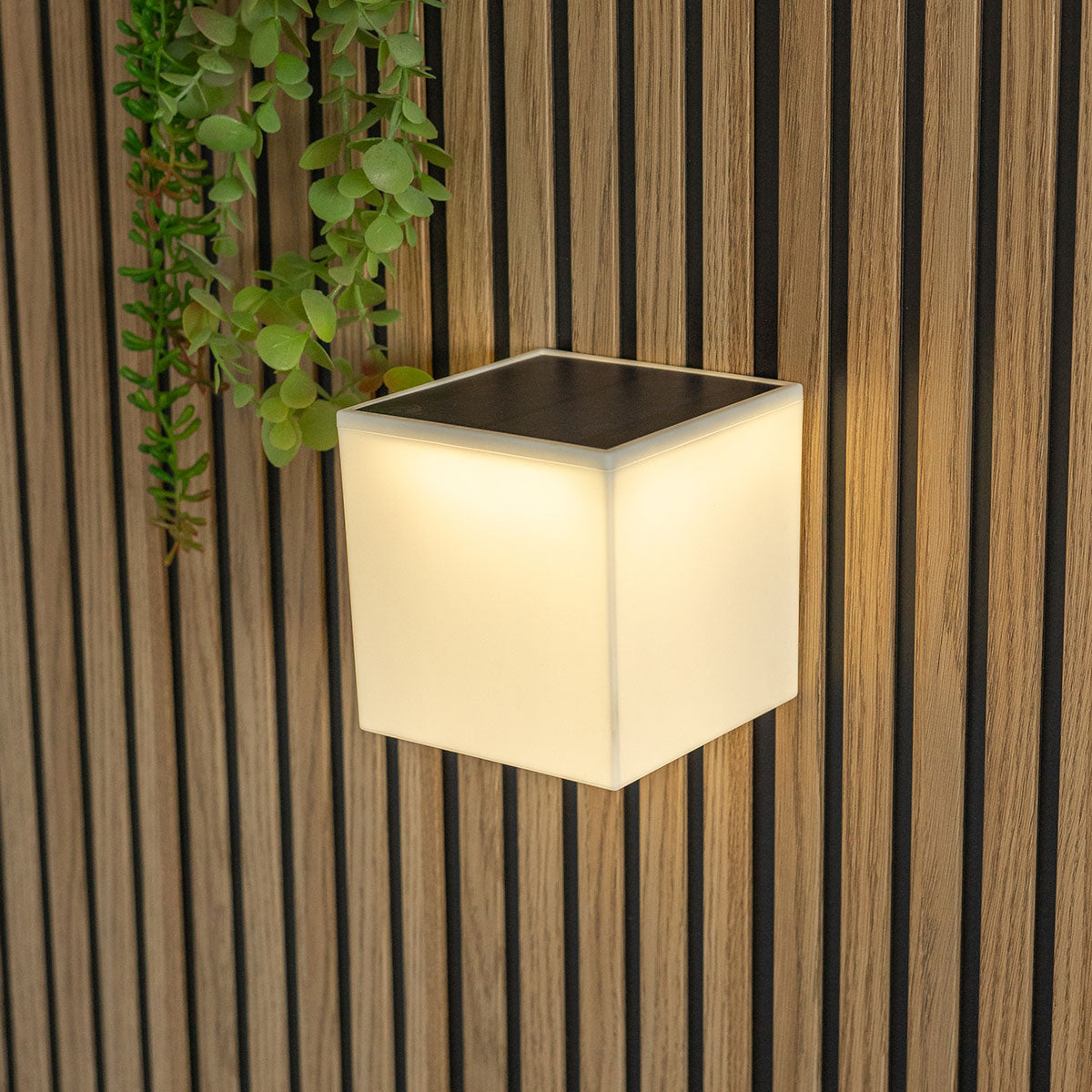 Applique solaire blanche en gros plan sur lambris bois, éclairage chaud diffus