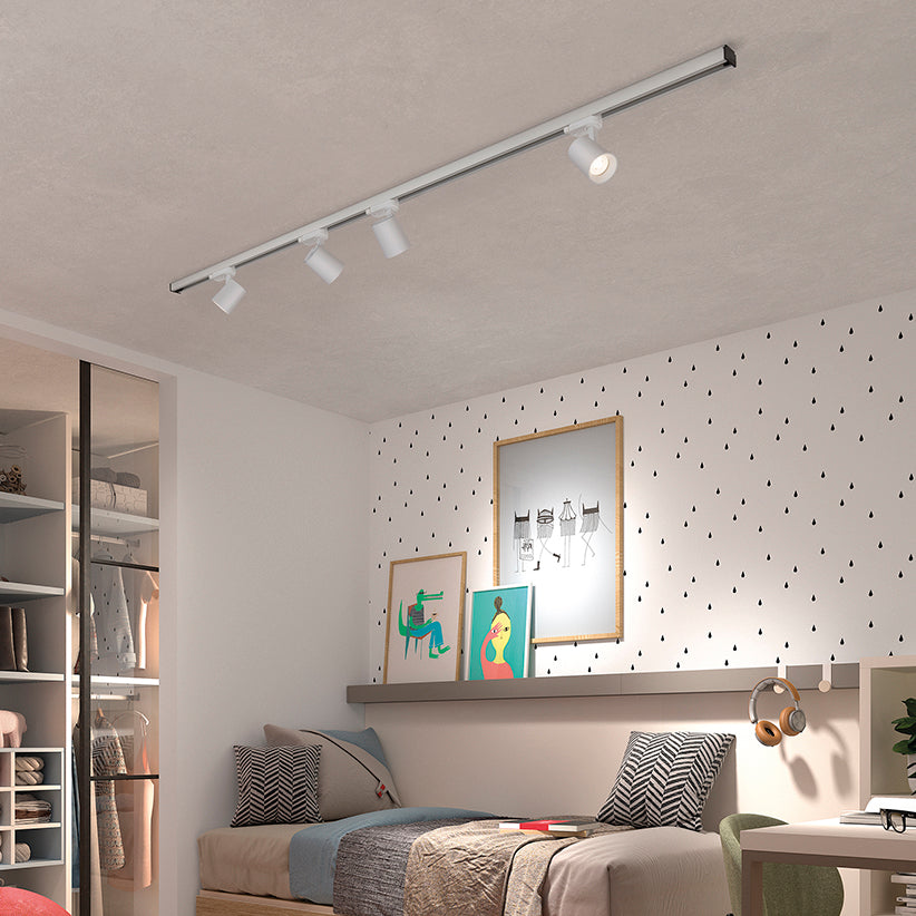 Vue de la même chambre avec le rail blanc allumé au-dessus du lit.