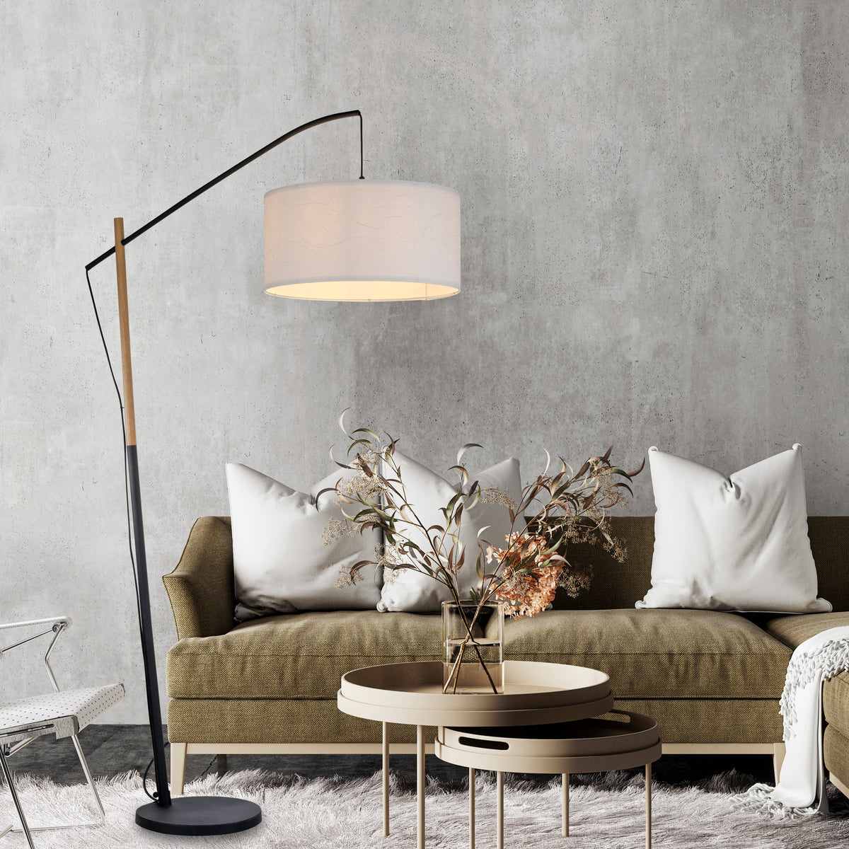 Mise en ambiance du lampadaire allumé au-dessus d'un canapé, coussins, table basse, mur béton.