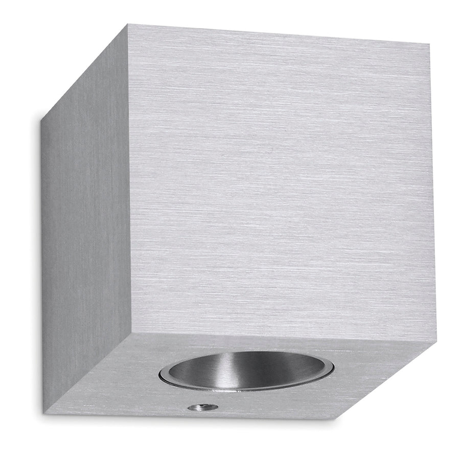 Applique murale cube en aluminium brossé, vue de trois quarts avec sortie lumineuse circulaire.