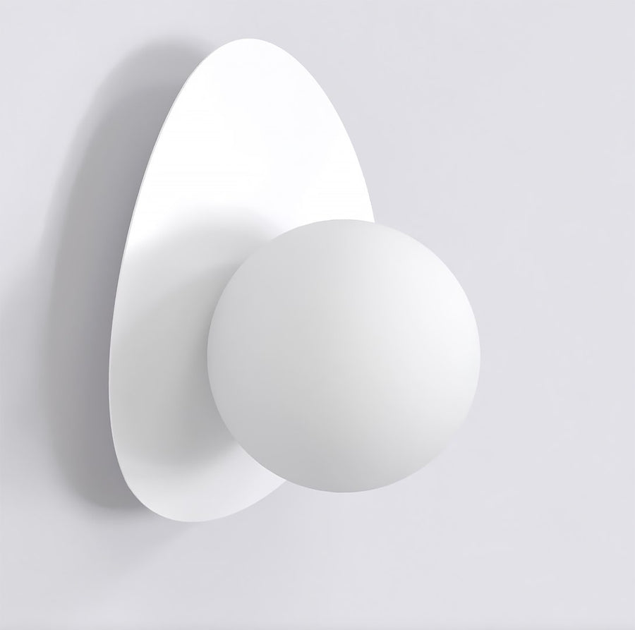 Vue de trois quarts d'une applique murale blanche à dos ovale et diffuseur sphérique.