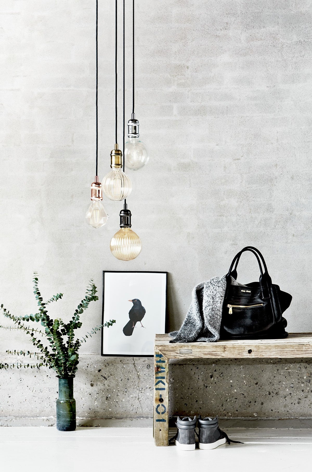 Mise en ambiance avec plusieurs suspensions, ampoules variées et décor en béton.