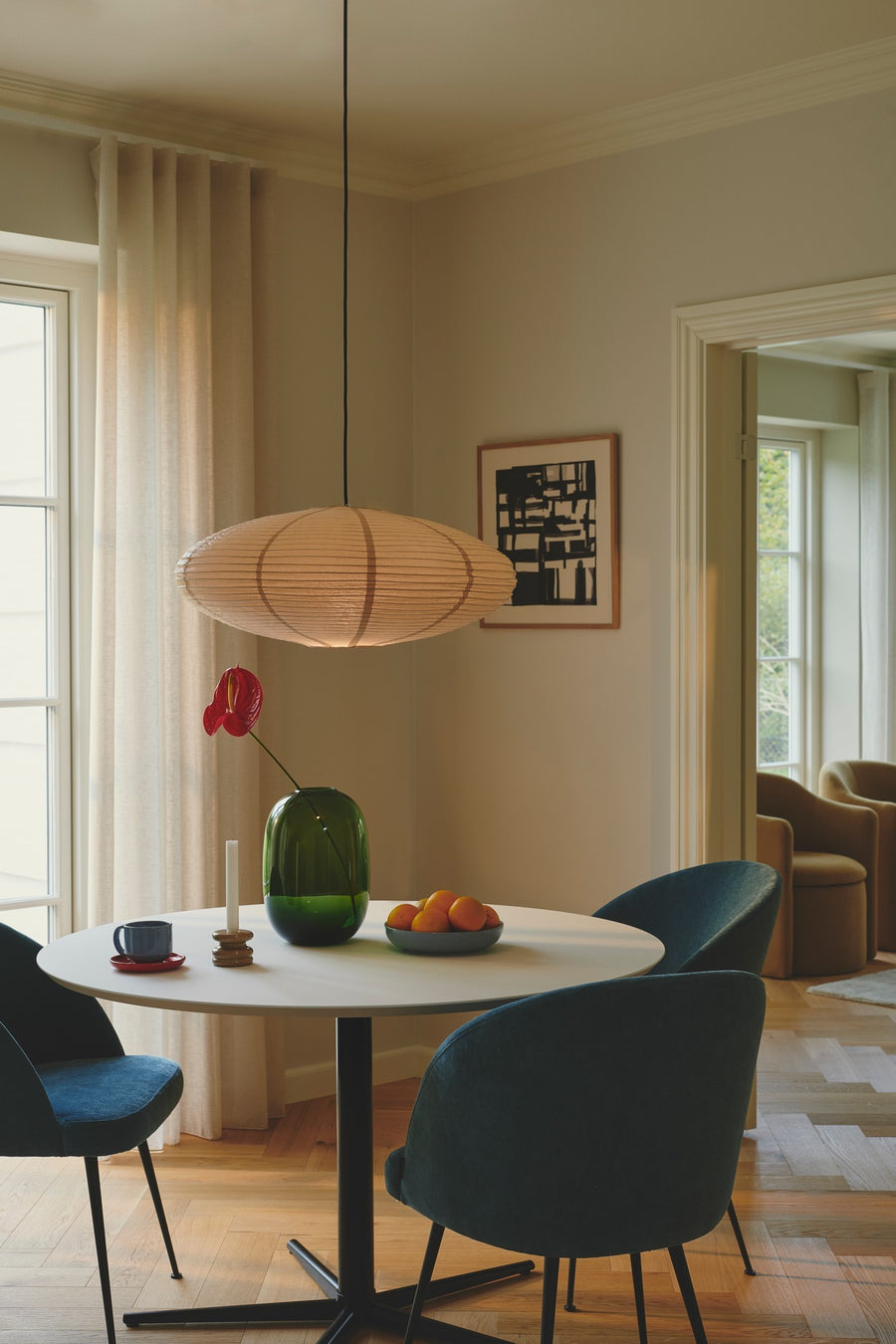 Vue en situation d'un cordon noir suspendu au-dessus d'une table ronde avec chaises bleues