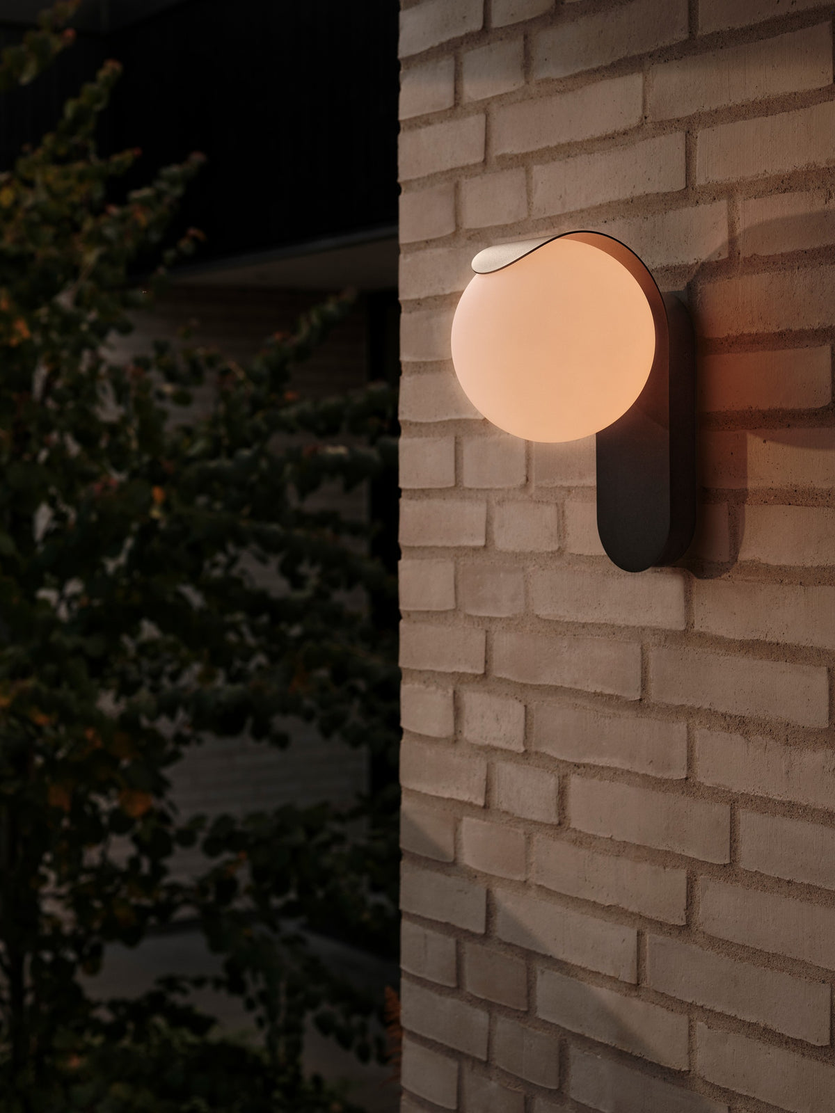 Mise en ambiance nocturne sur mur de briques, halo chaud diffus