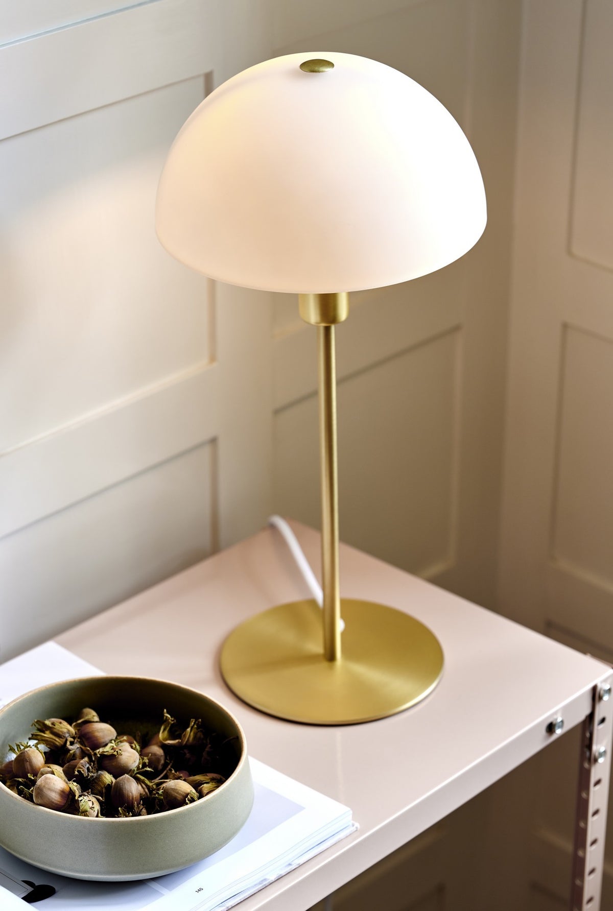Mise en ambiance sur une table d'appoint avec bol de noisettes et boiseries claires.