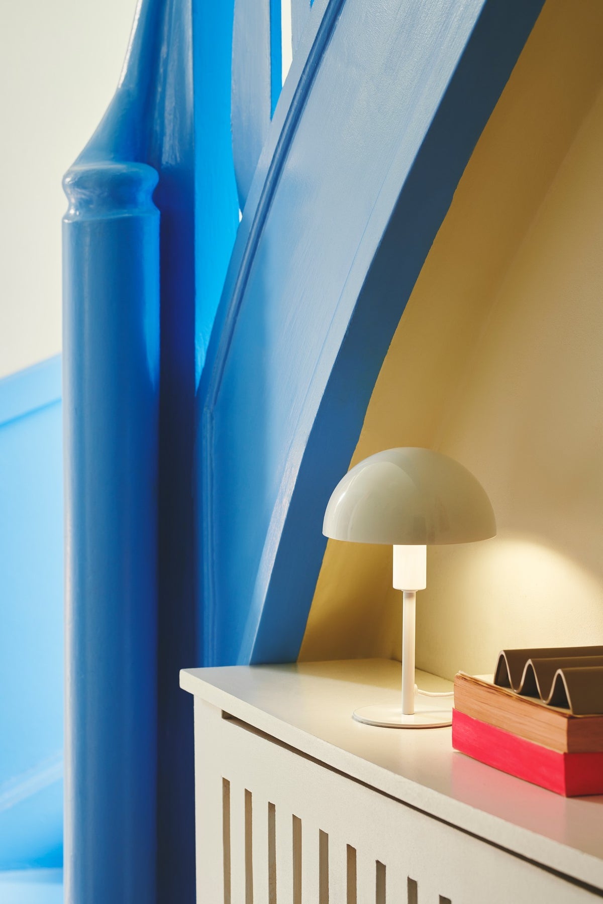 Mise en ambiance sur une commode blanche, chambre bleue, lampe allumée