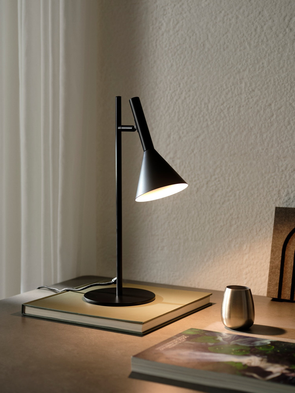 Lampe posée sur un livre dans un intérieur chaleureux, éclairage diffus