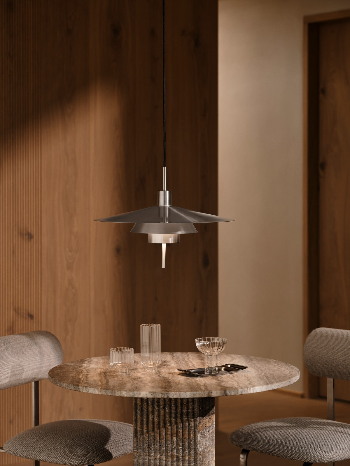 Mise en ambiance au-dessus d'une table ronde en pierre dans un intérieur bois.