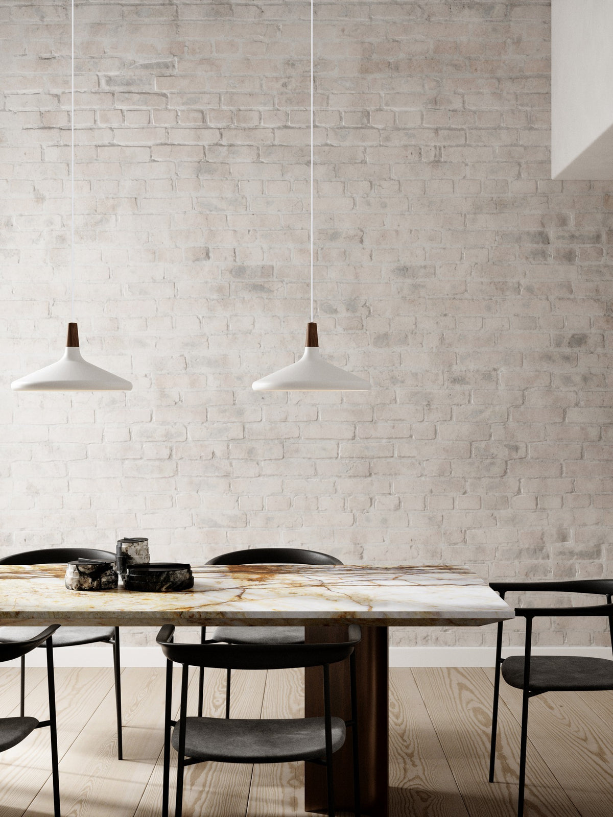 Mise en ambiance : deux suspensions blanches au-dessus d'une table en marbre et chaises noires.