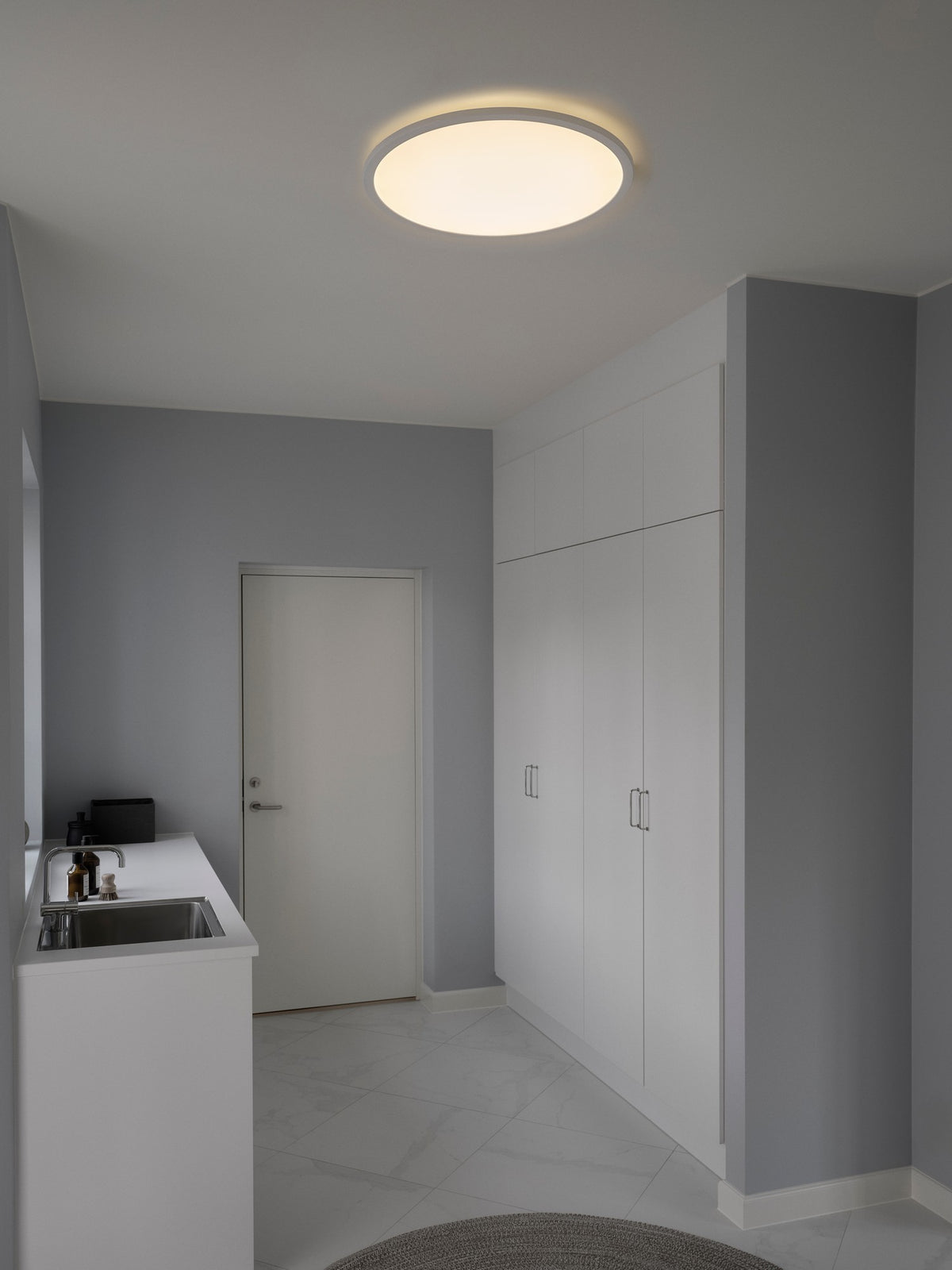 Mise en ambiance du plafonnier allumé au plafond d'une buanderie grise