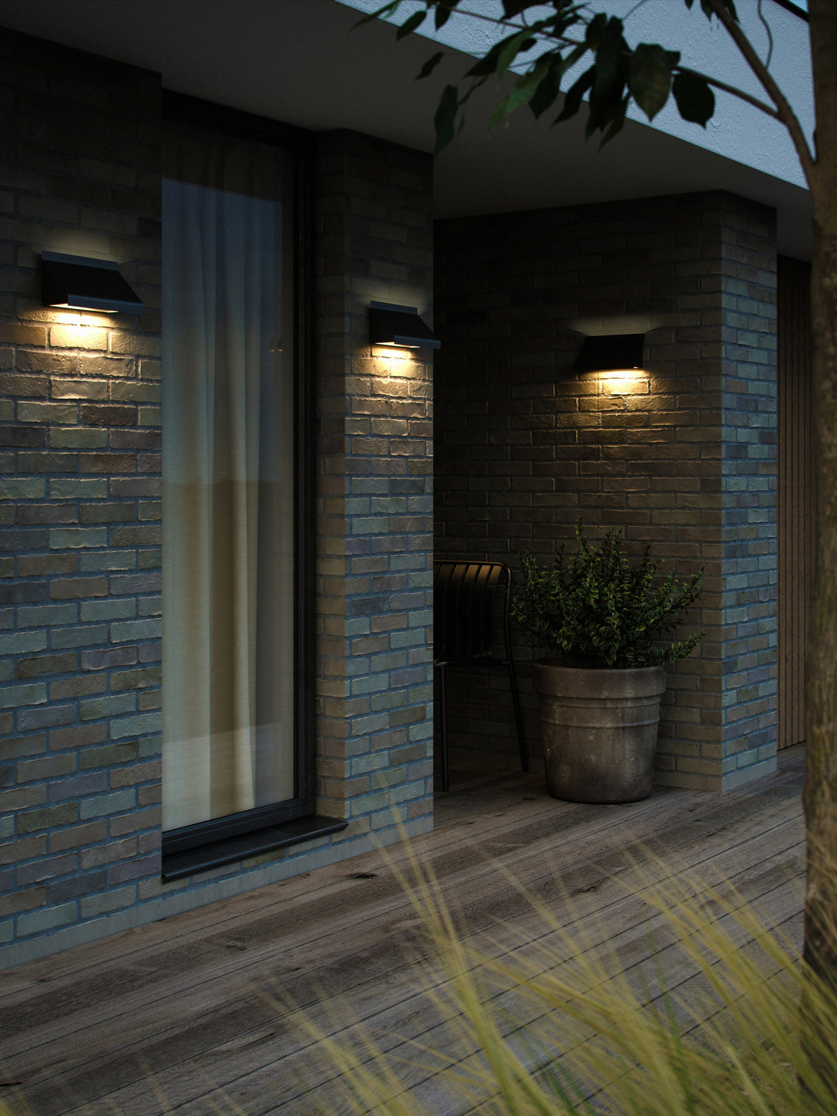 Mise en ambiance nocturne, trois appliques éclairant un mur de briques et une terrasse