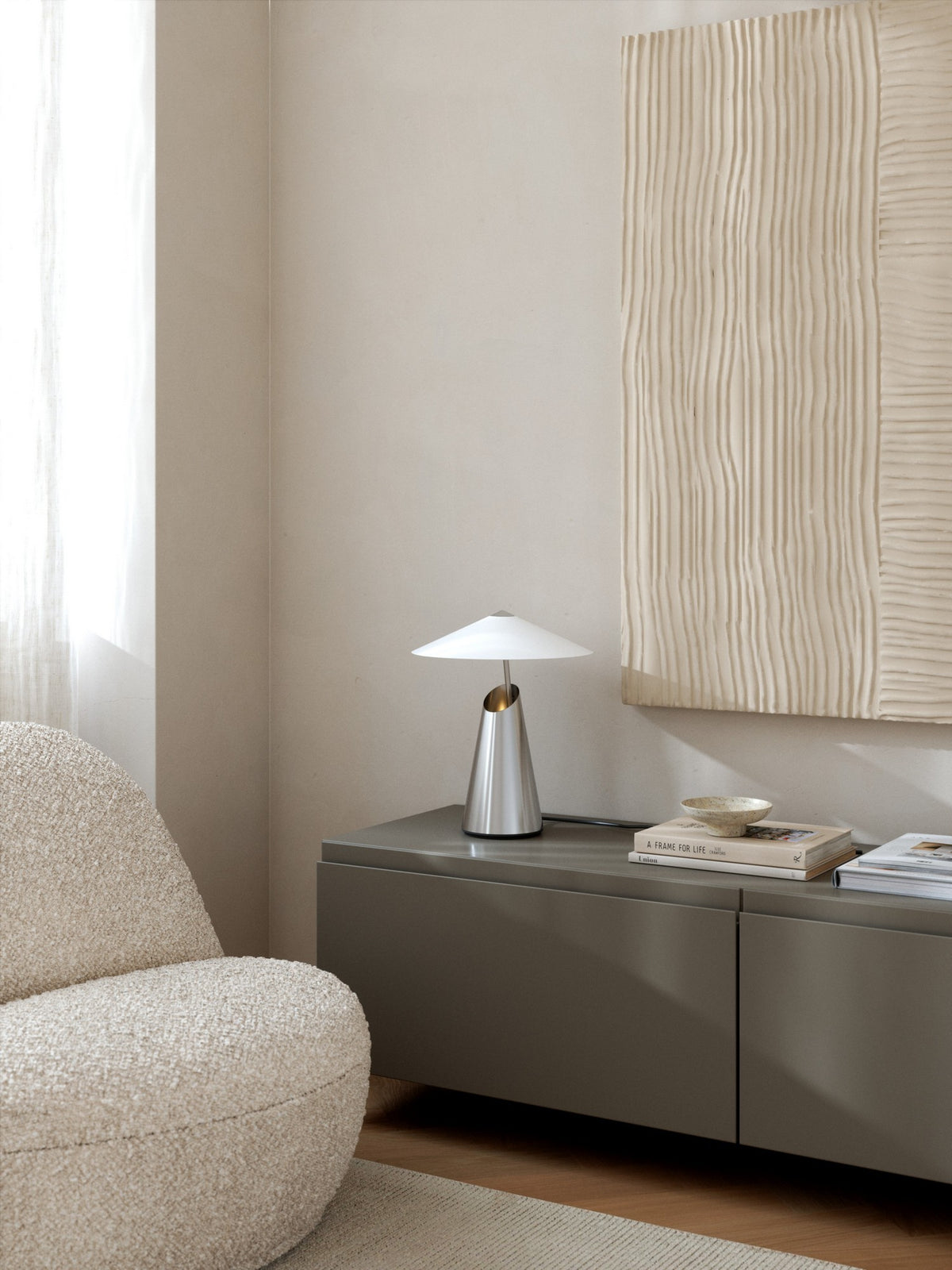 Mise en ambiance, lampe posée sur un meuble gris dans un intérieur beige