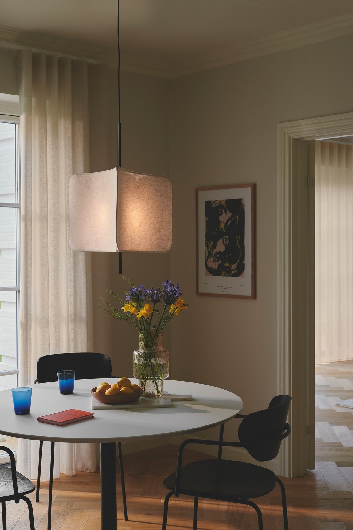 Lumière suspendue au-dessus d'une table ronde dressée avec vase de fleurs