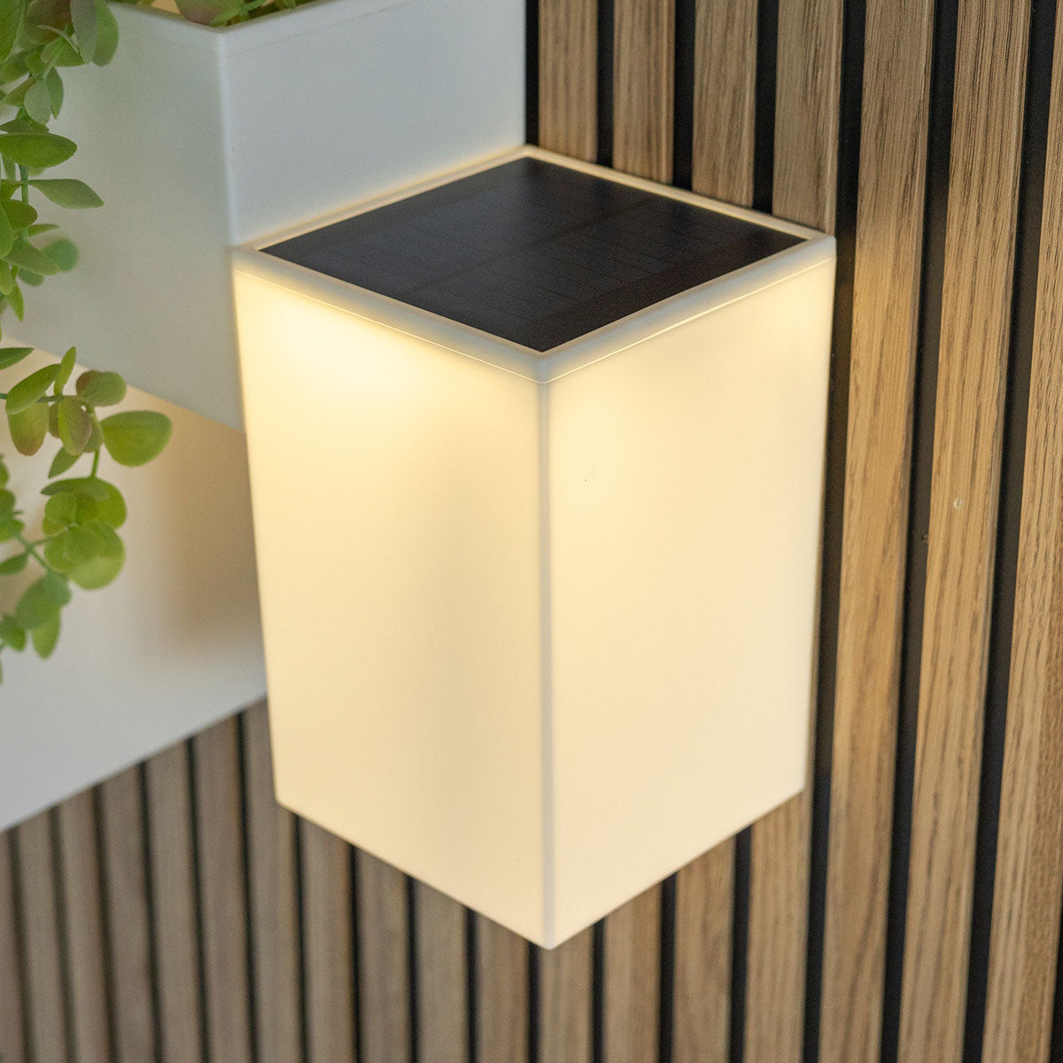 Vue rapprochée du cube lumineux montrant la finition blanche et le panneau solaire