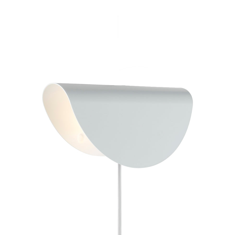 Vue rapprochée du luminaire blanc cassé, intérieur clair et tige apparente.