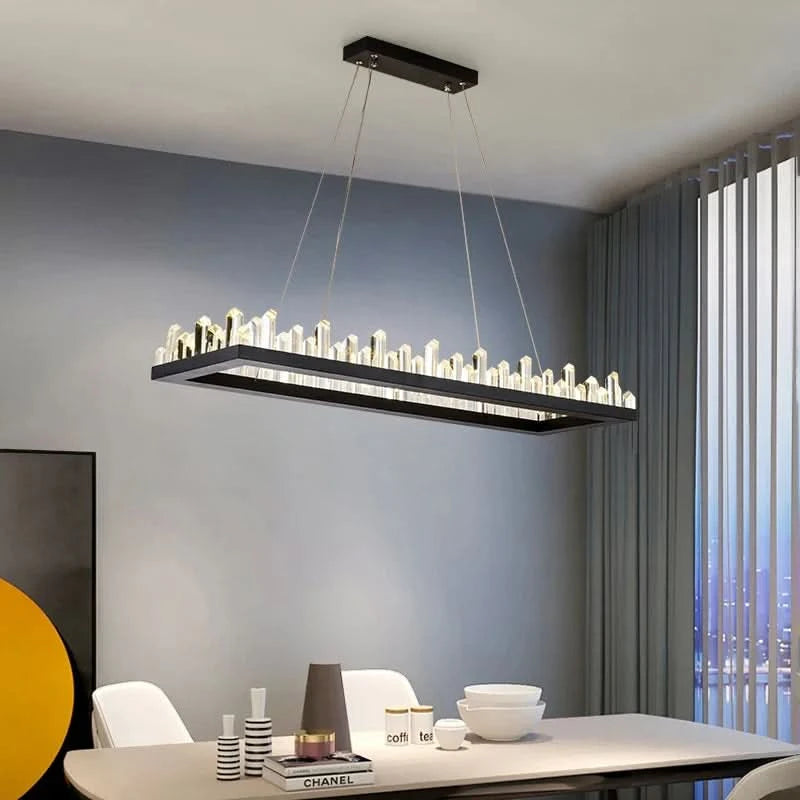 Suspension rectangulaire noire avec cristaux verticaux éclairés, au-dessus d'une table de salle à manger.