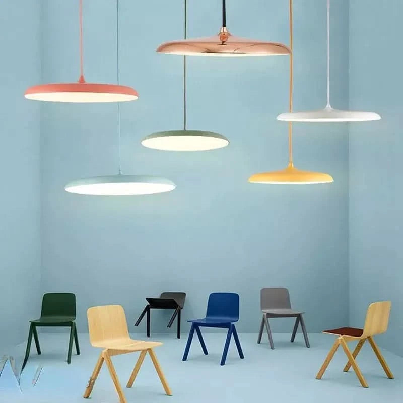 Suspensions colorées suspendues au-dessus de chaises dans une pièce pastel.