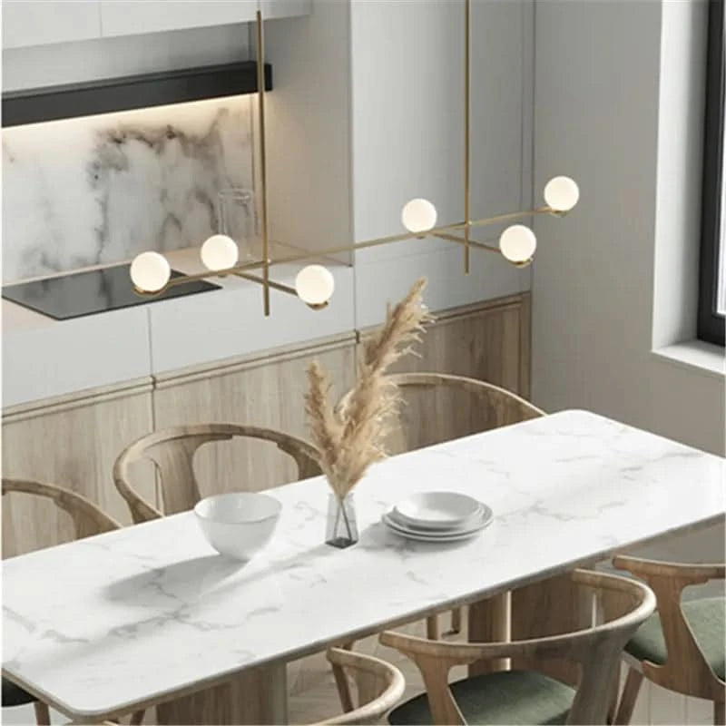 Lustre doré à six globes au-dessus d'une table en marbre, détails de la finition.