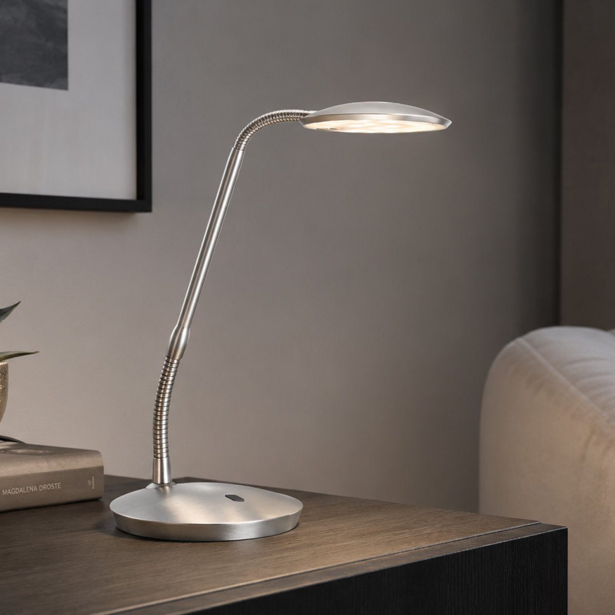 Lampe à poser allumée sur une table en bois, intérieur contemporain en arrière-plan