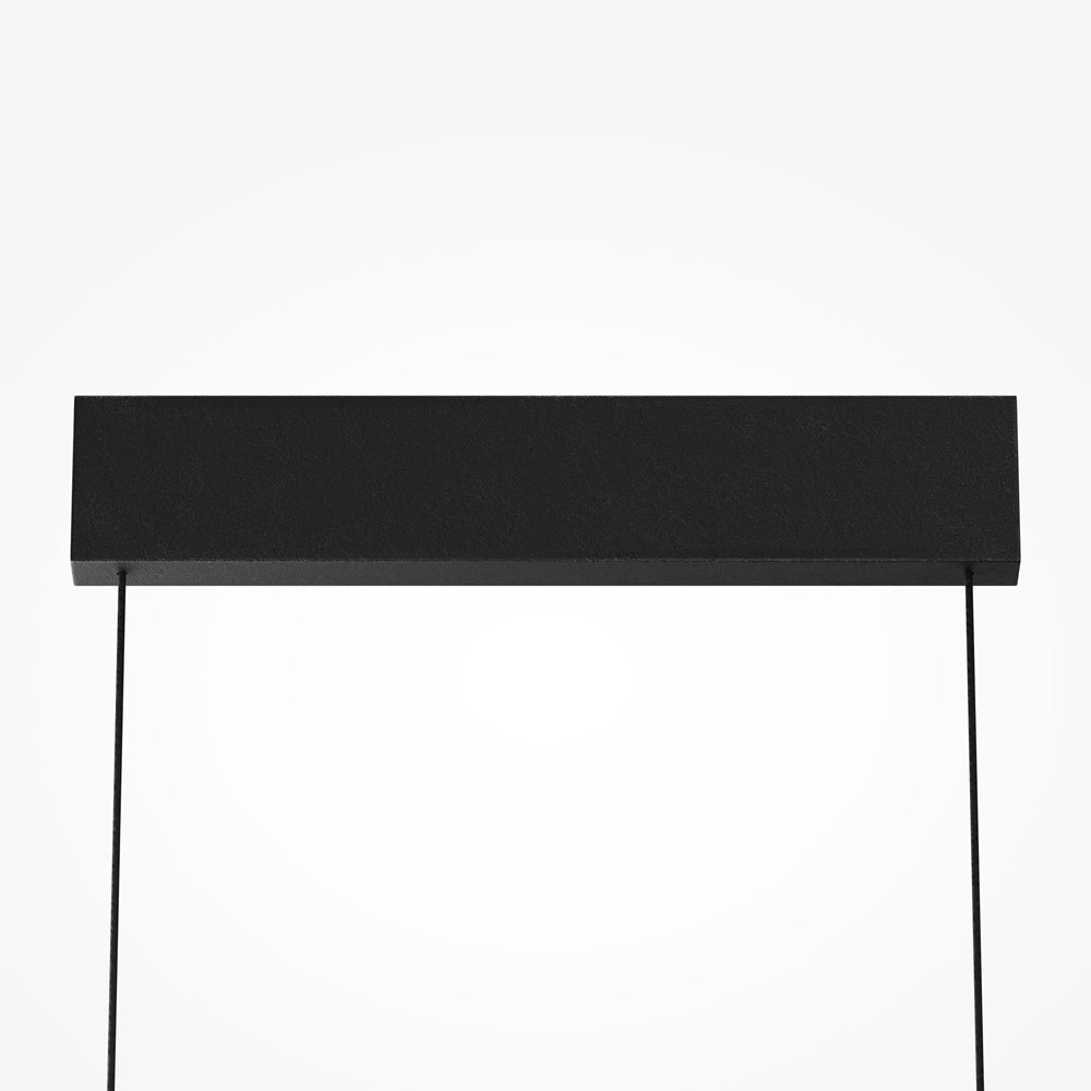Détail de la platine de plafond rectangulaire noire et des deux câbles de suspension.