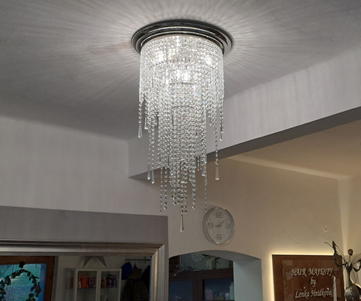 Luminaire allumé fixé au plafond, halo lumineux projeté sur la surface blanche