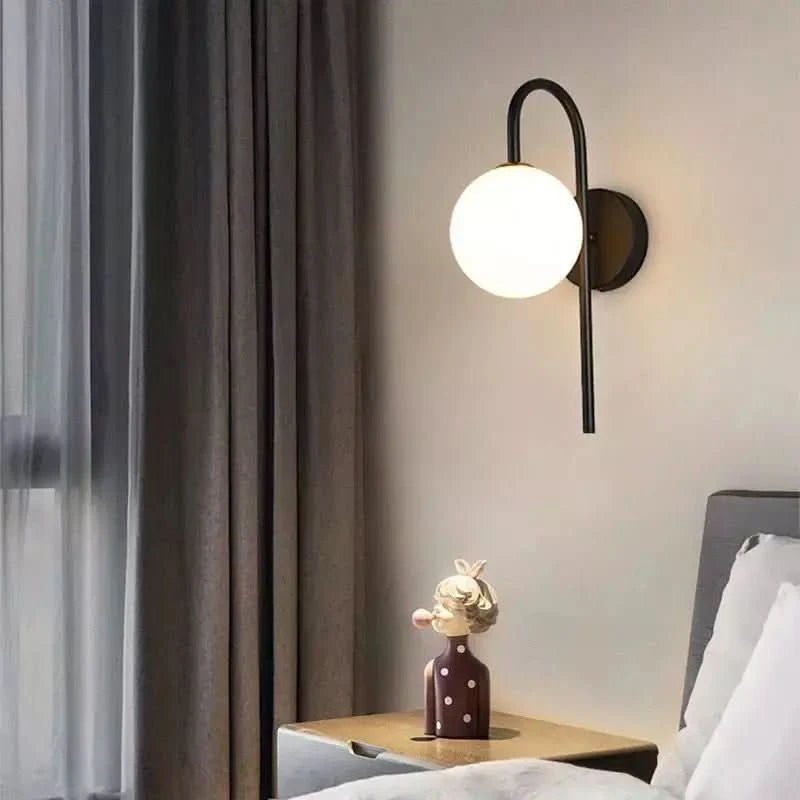 Version noire fixée au mur près d'un lit, rideaux gris et veilleuse