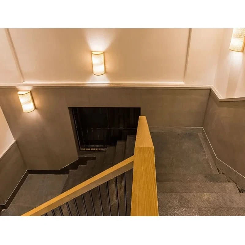 Vue en plongée d'un escalier éclairé par deux appliques murales allumées