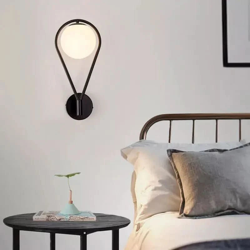 Modèle noir suspendu au-dessus d'une table de chevet, près d'un lit en métal