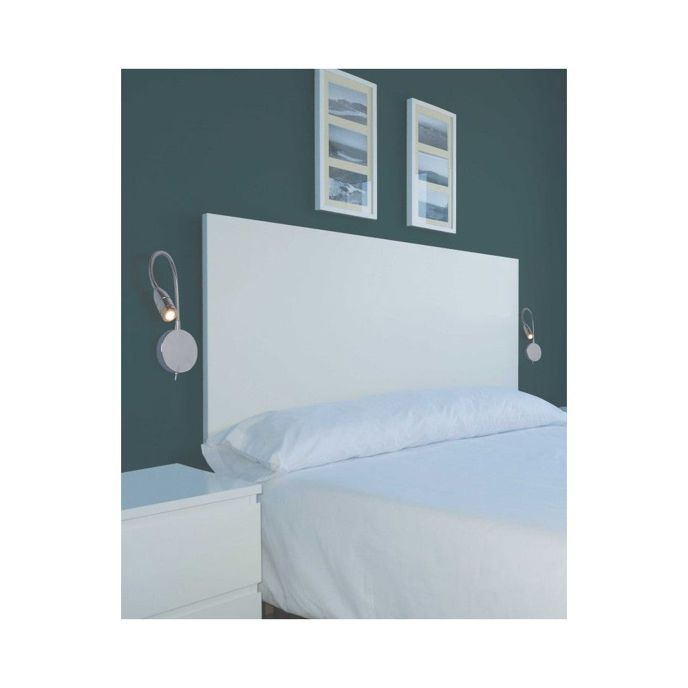 Mise en ambiance de deux appliques murales de part et d'autre d'une tête de lit blanche.