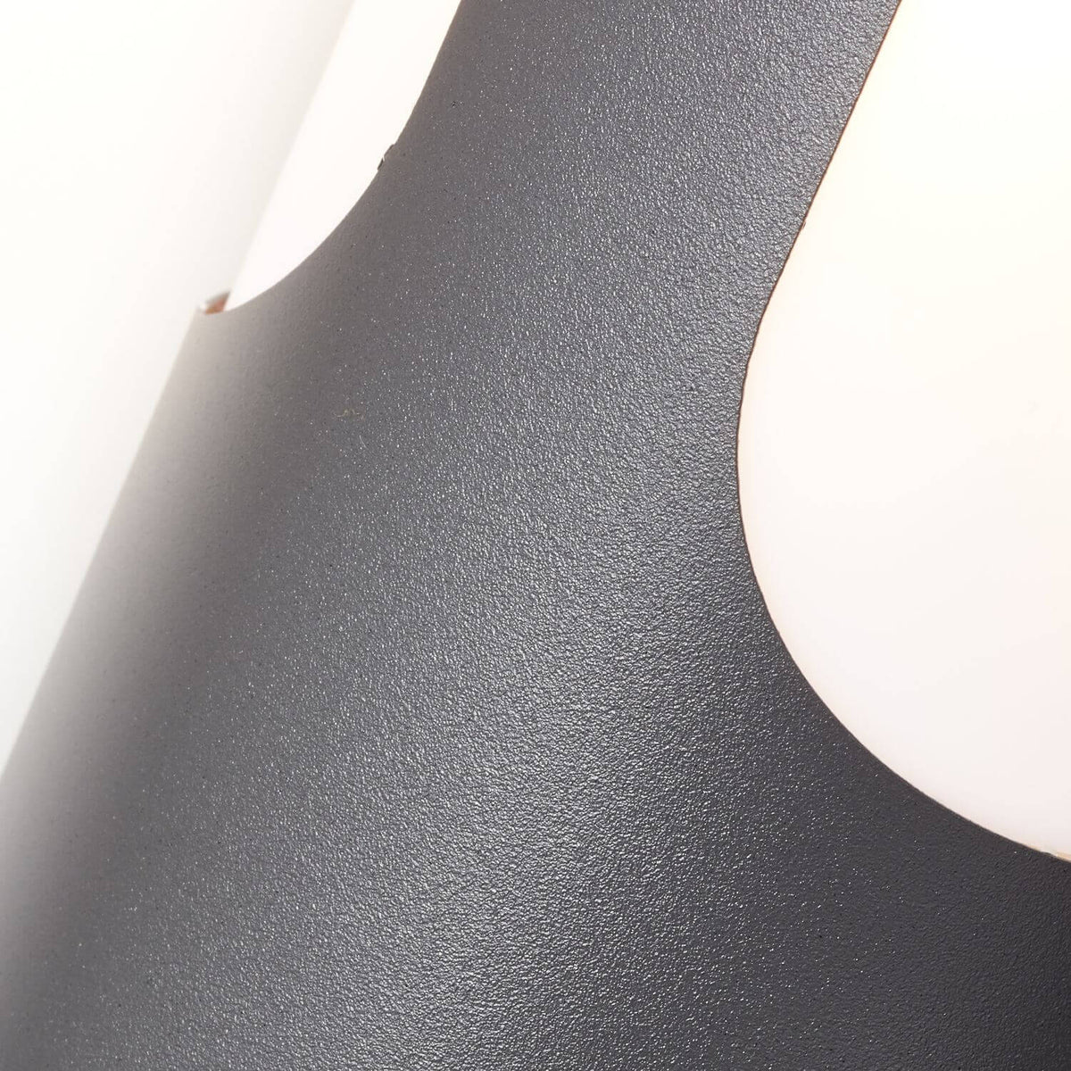 Détail rapproché de la finition texturée anthracite et du bord du diffuseur blanc