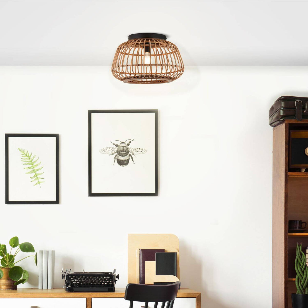 Mise en ambiance du plafonnier installé au-dessus d'un bureau, mur blanc, cadres noirs