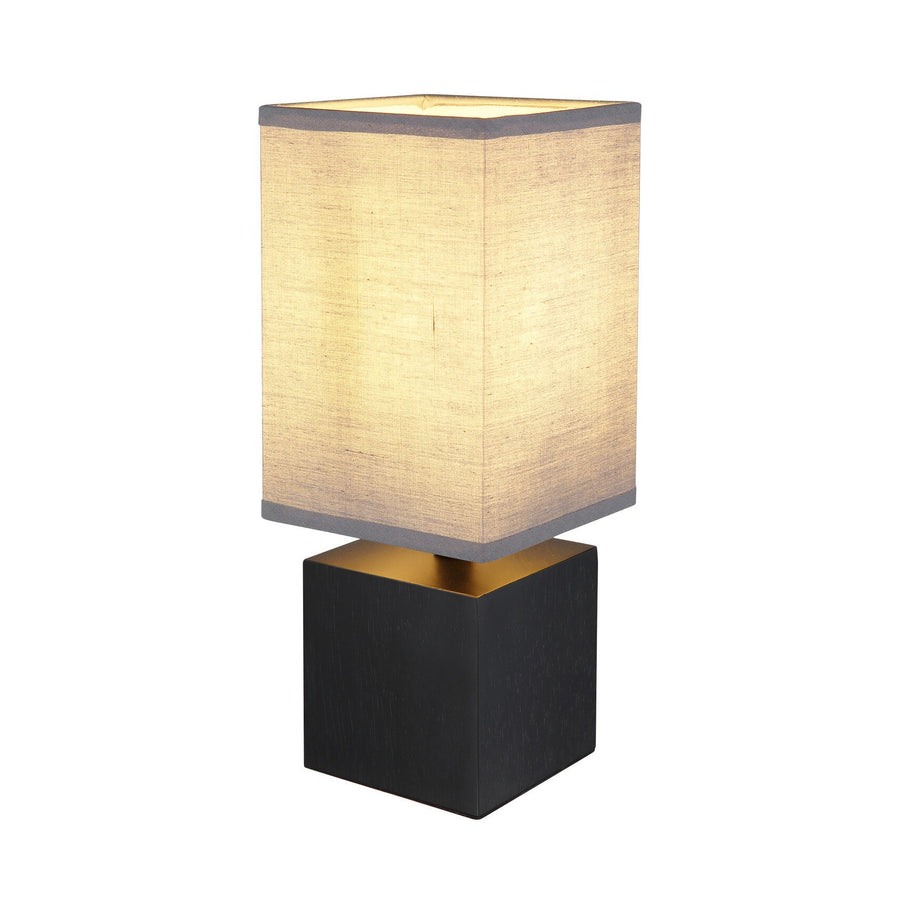 Lampe à poser allumée, vue de trois quarts sur fond blanc neutre