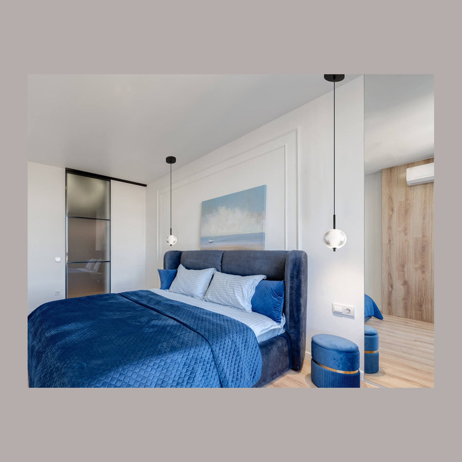 Suspension noire installée de chaque côté du lit dans une chambre bleu nuit contemporaine