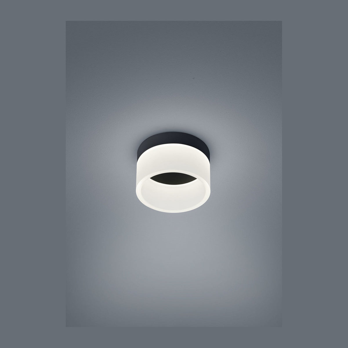 Plafonnier cylindrique noir et blanc photographié de face sur fond gris uni