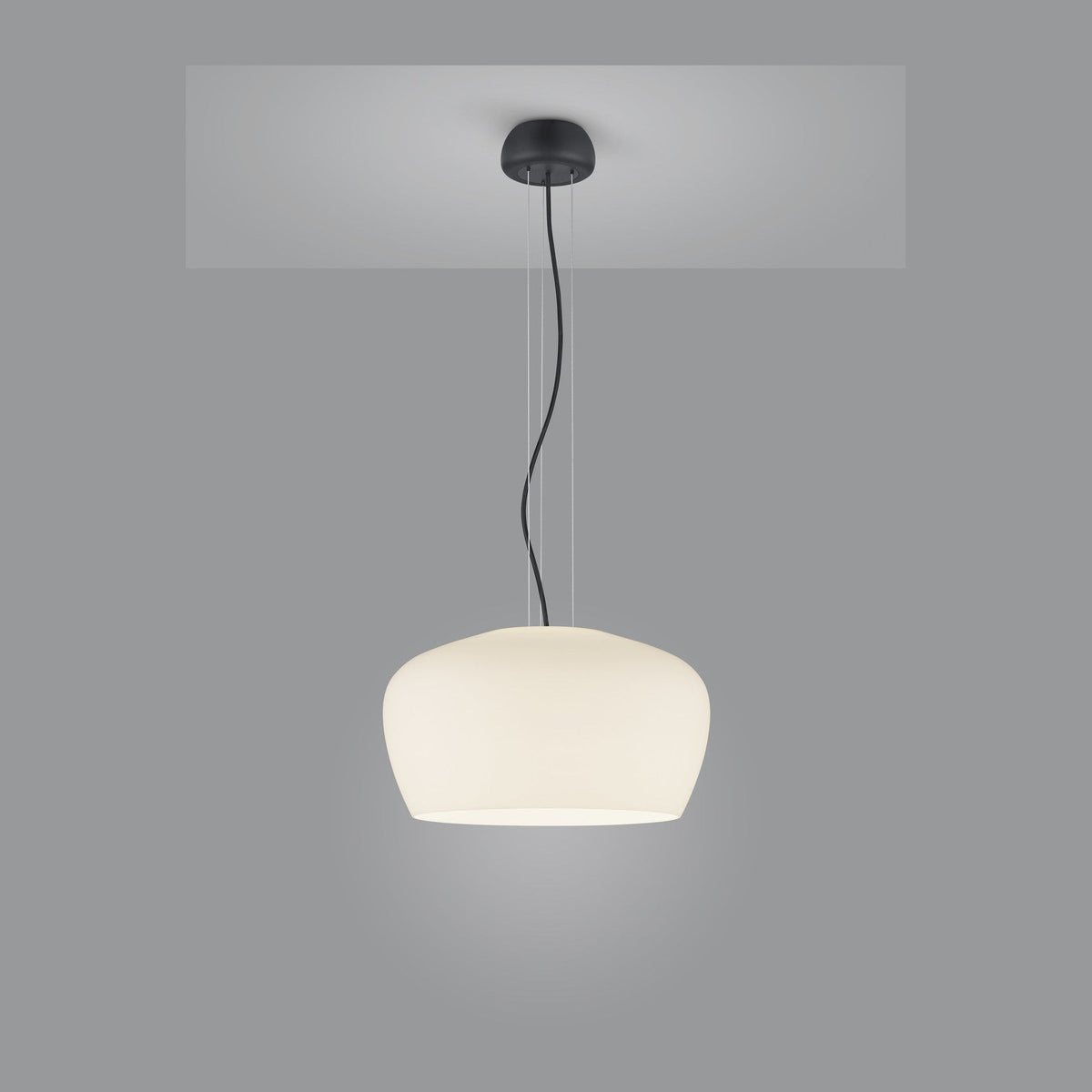 Suspension au diffuseur blanc ivoire, câble noir et rosace fixée au plafond.