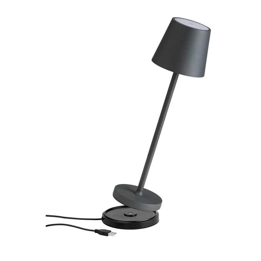 Lampe à poser sans fil inclinée sur fond blanc avec câble USB et socle séparé