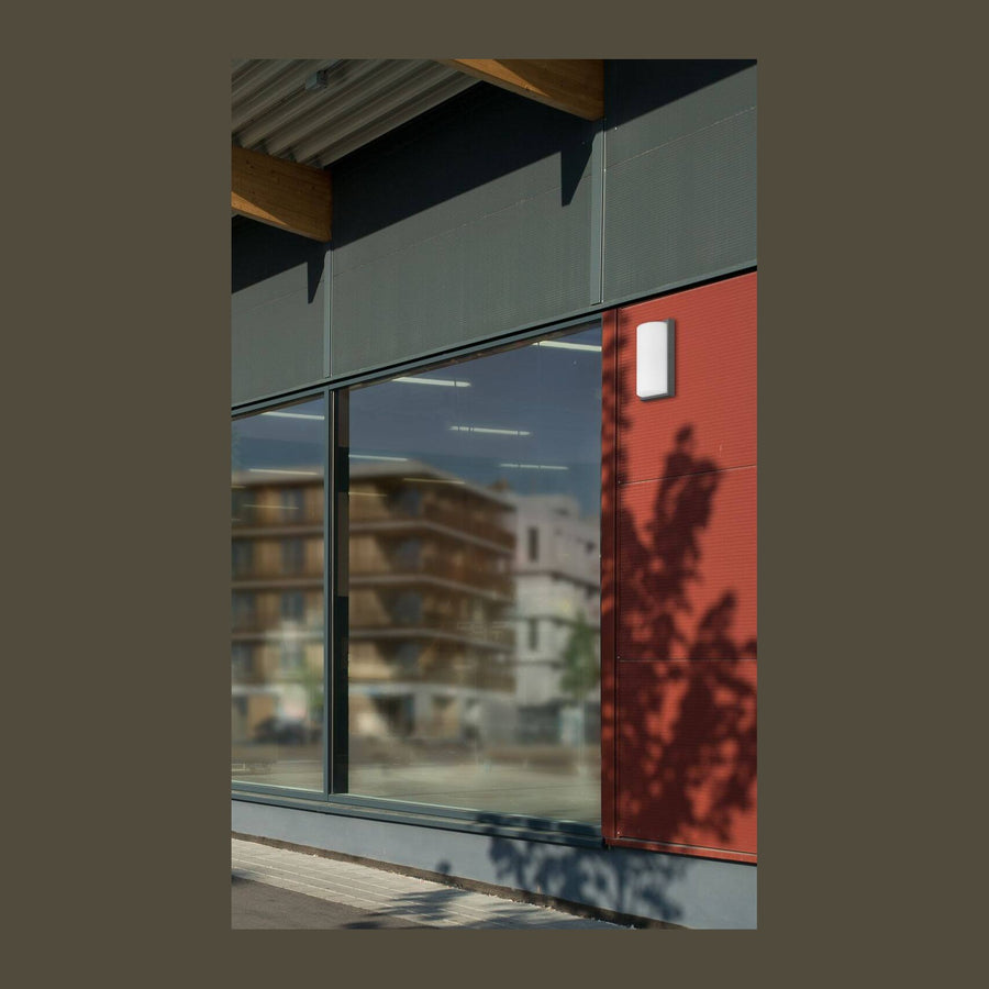 Façade rouge avec applique murale anthracite fixée près de la fenêtre vitrée