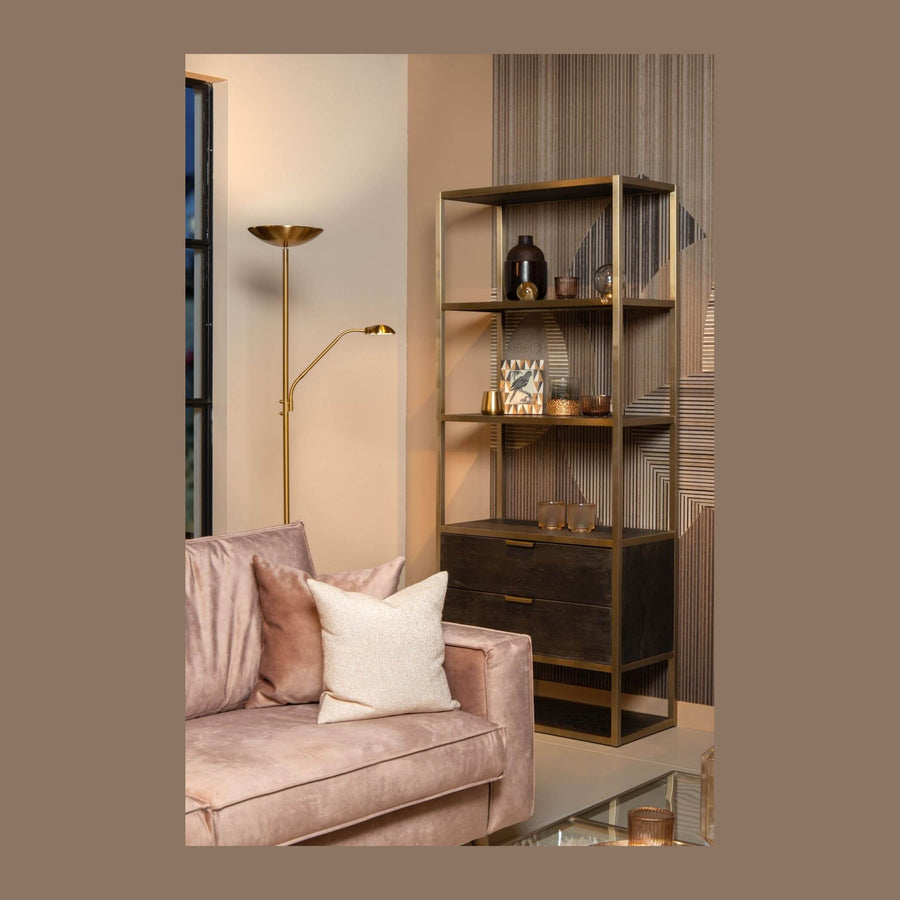 Lampadaire doré posé près d'un canapé rose dans un salon contemporain
